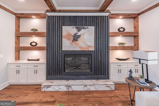 details with crown molding, wood finished floors, built in features, and a glass covered fireplace