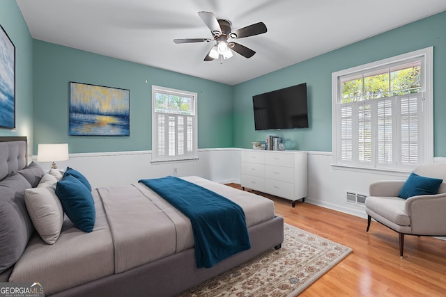 bedroom with visible vents, baseboards, a ceiling fan, and wood finished floors