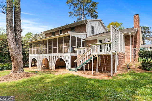 back of house with a sunroom, a lawn, stairway, brick siding, and a chimney