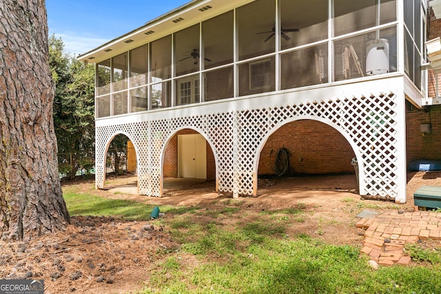rear view of house featuring a sunroom and ceiling fan