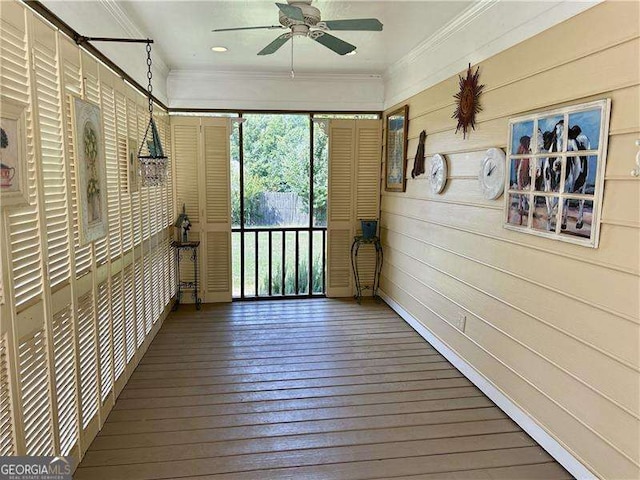 unfurnished sunroom featuring ceiling fan