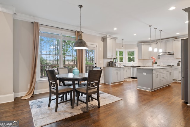 dining room featuring dark wood finished floors, baseboards, crown molding, and recessed lighting