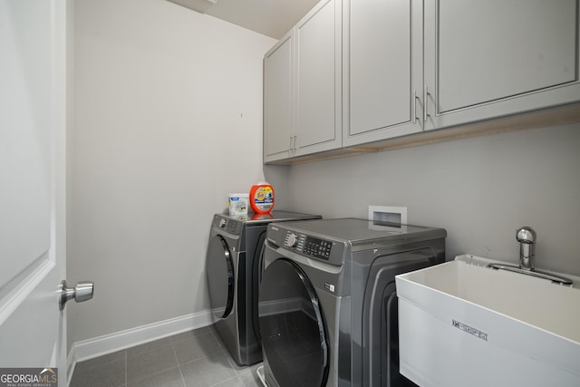 washroom featuring tile patterned flooring, washer and clothes dryer, baseboards, a sink, and cabinet space