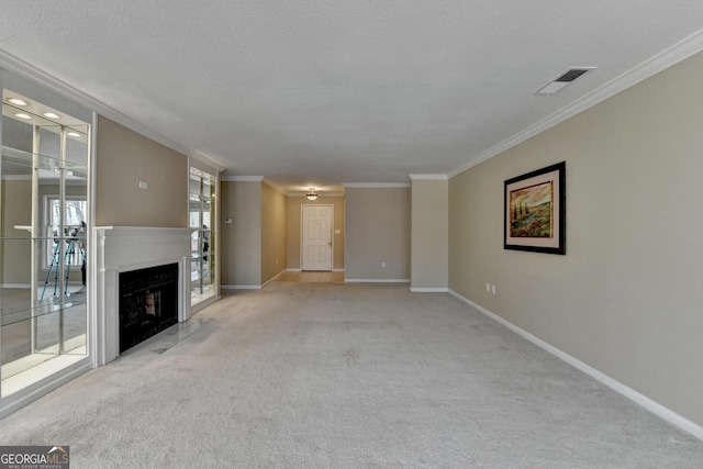 unfurnished living room featuring visible vents, baseboards, a fireplace, ornamental molding, and carpet floors