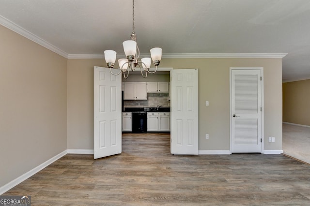 kitchen featuring baseboards, dark countertops, black dishwasher, and a notable chandelier