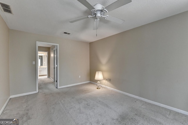 carpeted spare room featuring a ceiling fan, baseboards, and visible vents