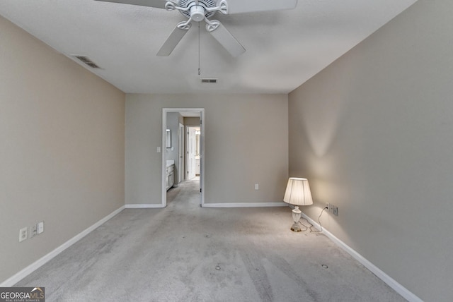 carpeted empty room with baseboards, visible vents, and ceiling fan
