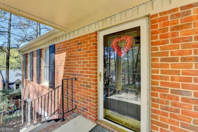 doorway to property featuring brick siding