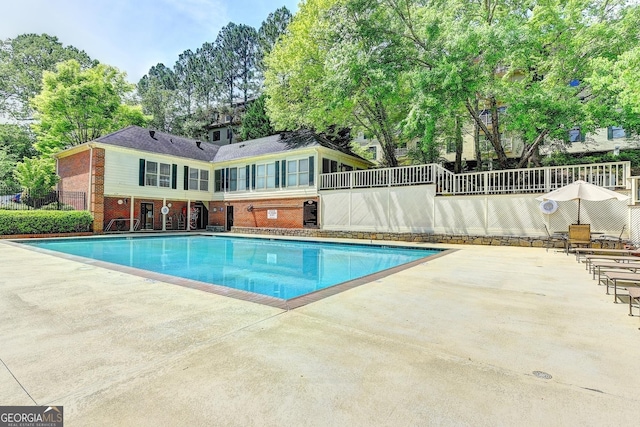 pool featuring fence and a patio
