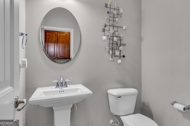 half bathroom featuring toilet and a sink