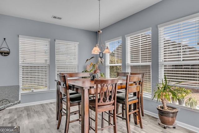 dining area featuring baseboards, visible vents, and wood finished floors