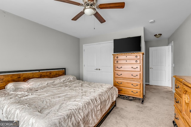 bedroom with ceiling fan, a closet, and light colored carpet