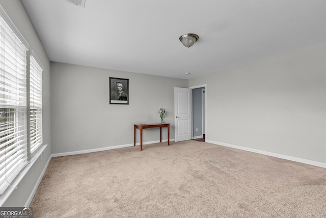 carpeted empty room with baseboards