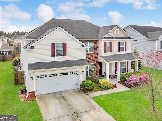 traditional-style house with a porch, fence, driveway, a front lawn, and an attached garage