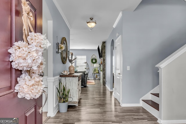 foyer with stairway, wood finished floors, and crown molding