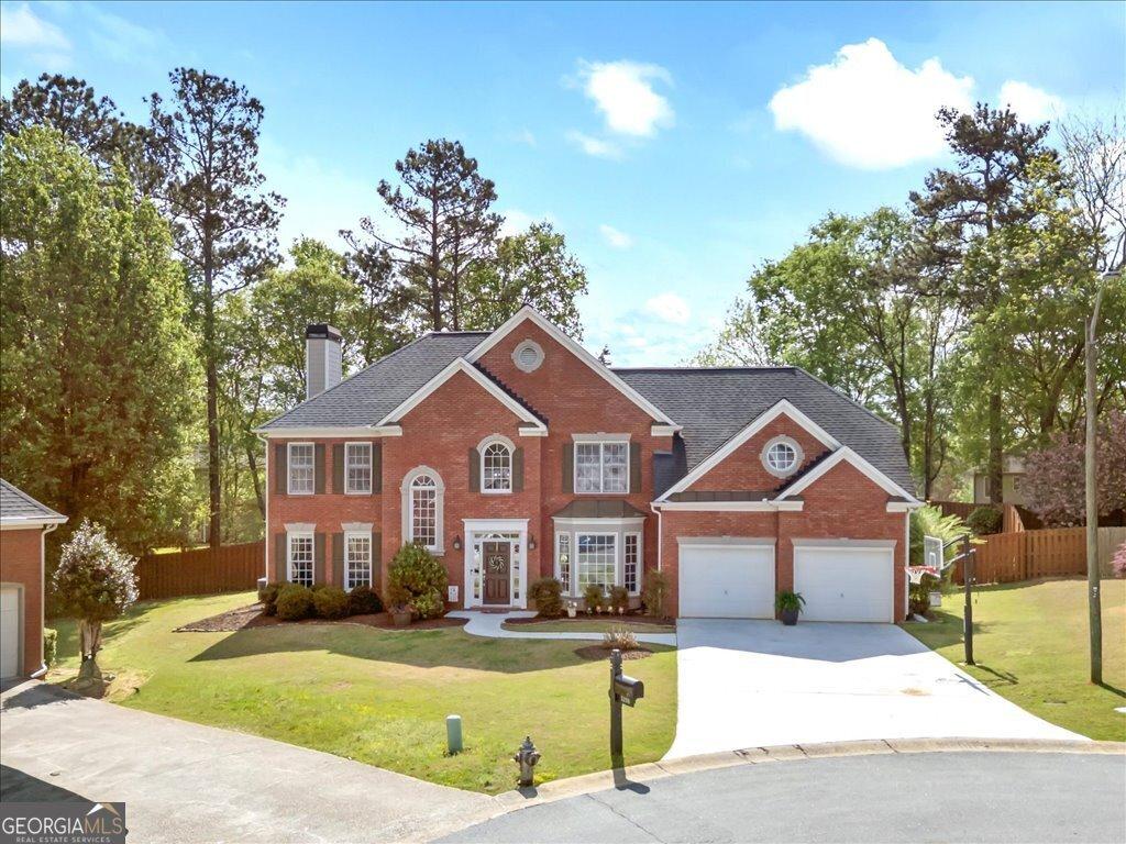 5296 Camden Lake Pkwy NW, Acworth, GA 30101 - view of front facade with brick siding, fence, and concrete driveway