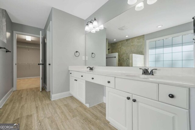 4522 Willow Oak Trl, Powder Springs, GA 30127 - bathroom featuring walk in shower, baseboards, double vanity, wood finished floors, and a walk in closet