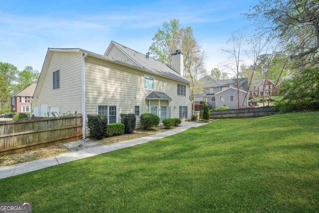 4522 Willow Oak Trl, Powder Springs, GA 30127 - back of property with a lawn, a chimney, and fence