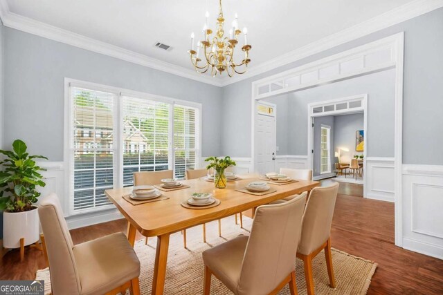 4522 Willow Oak Trl, Powder Springs, GA 30127 - dining space featuring a wainscoted wall, ornamental molding, wood finished floors, and a chandelier