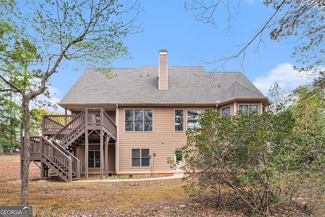 7497 Treehouse Ct, Douglasville, GA 30135 - rear view of property featuring a shingled roof, a wooden deck, a chimney, and stairs