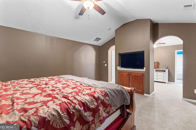 bedroom featuring a textured ceiling, visible vents, arched walkways, vaulted ceiling, and light carpet
