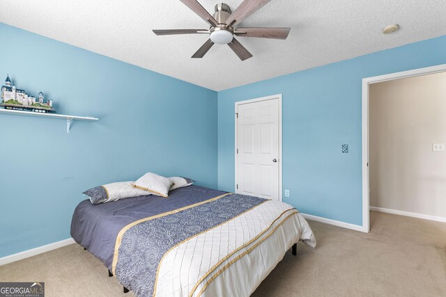 bedroom with baseboards, carpet flooring, and a textured ceiling