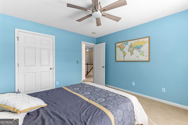 bedroom with baseboards, a ceiling fan, carpet flooring, and a textured ceiling