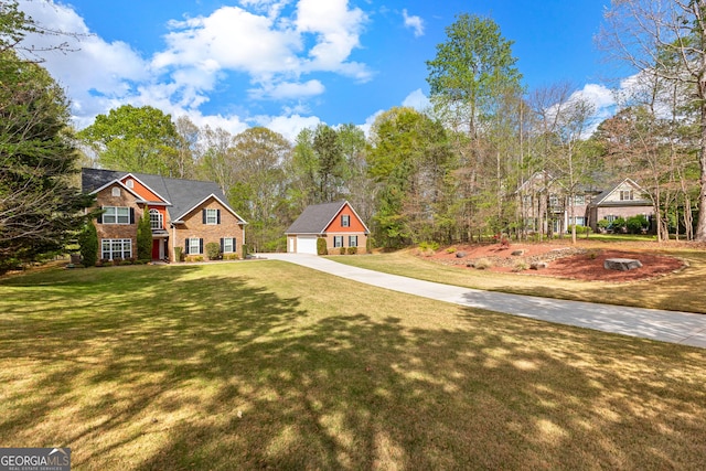 view of front of house with an outbuilding, a front yard, and concrete driveway