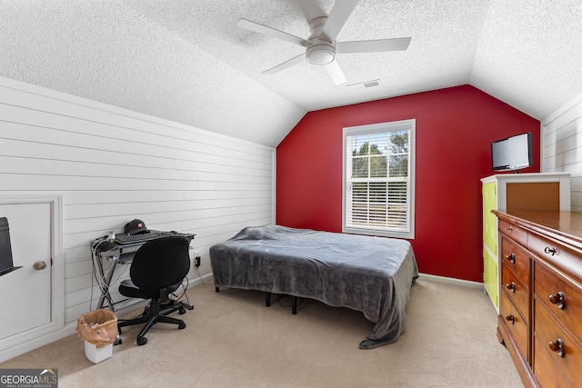bedroom featuring lofted ceiling, a textured ceiling, and visible vents
