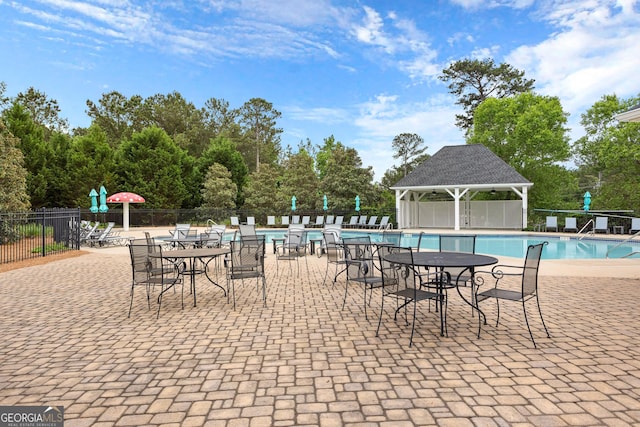 community pool featuring a gazebo, fence, and a patio area