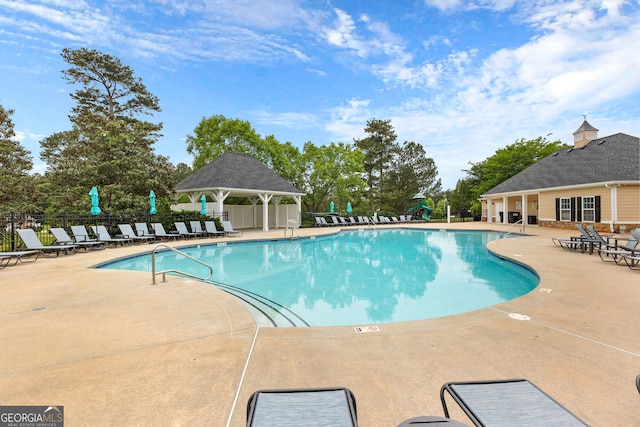 pool featuring fence, a gazebo, and a patio area