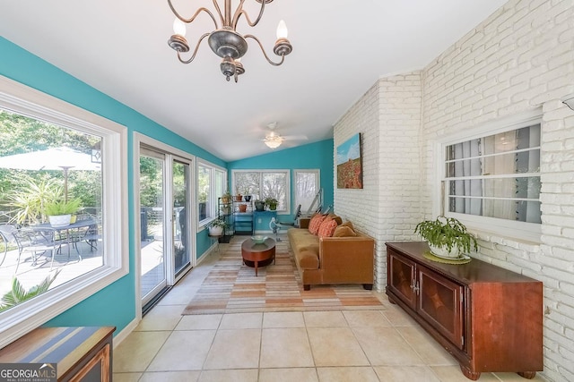 sunroom with tile patterned floors, an inviting chandelier, brick wall, and lofted ceiling