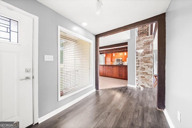foyer featuring baseboards and wood finished floors