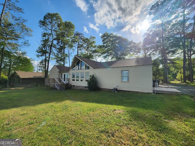 rear view of property featuring crawl space, a yard, and a wooden deck