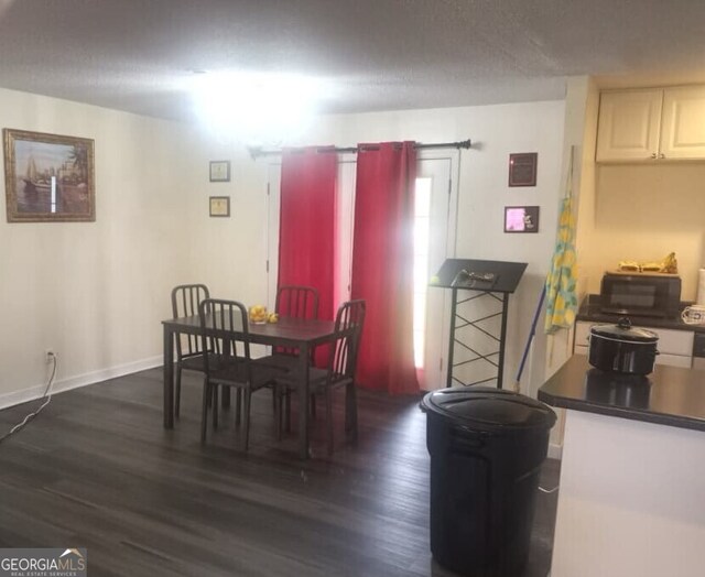 dining area with baseboards and dark wood-type flooring