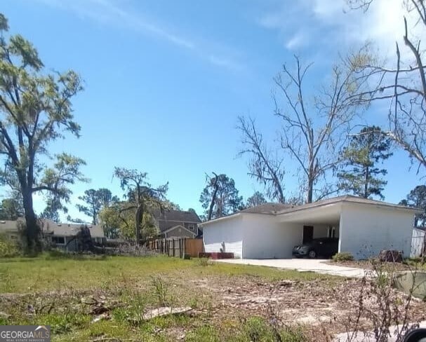 exterior space featuring an attached carport and stucco siding