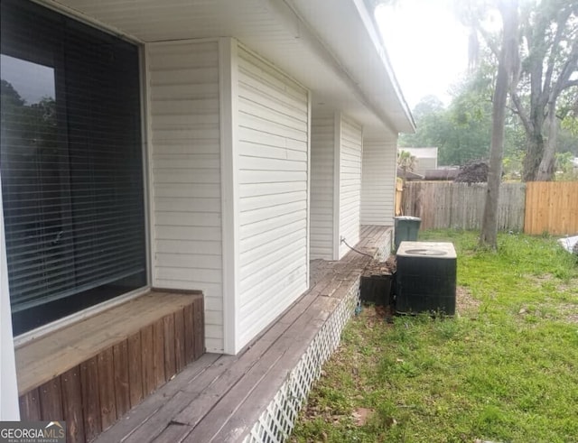 view of home's exterior with central AC unit, fence, and a yard