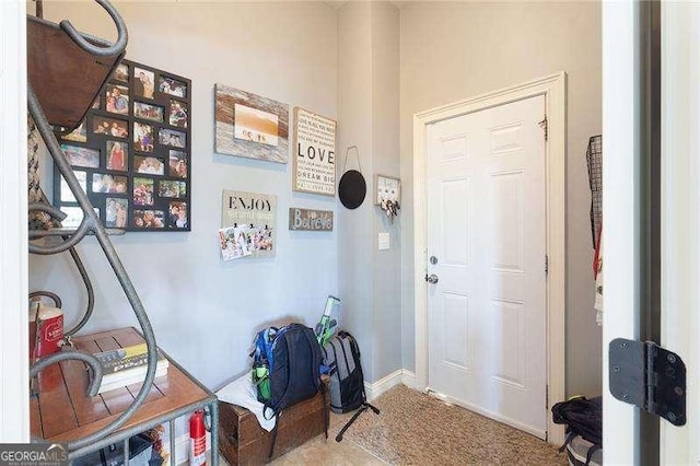 carpeted entryway featuring baseboards