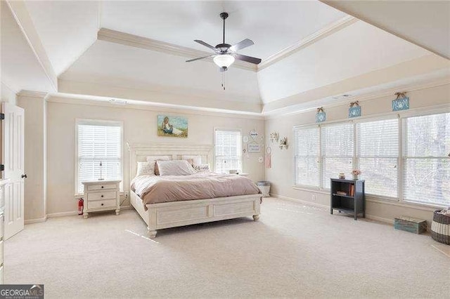 carpeted bedroom featuring a raised ceiling, crown molding, and multiple windows