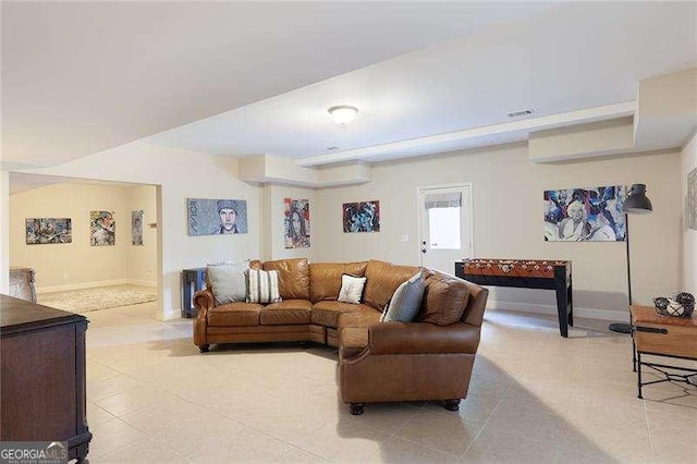 living room with baseboards, visible vents, and light tile patterned floors