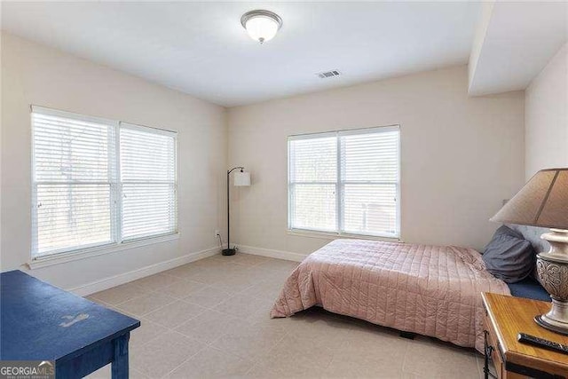 bedroom with baseboards and visible vents