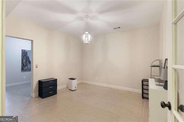 unfurnished room with baseboards and visible vents