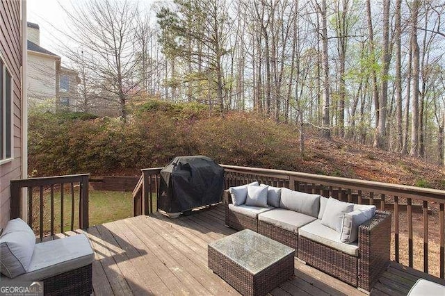 wooden terrace with outdoor lounge area and grilling area