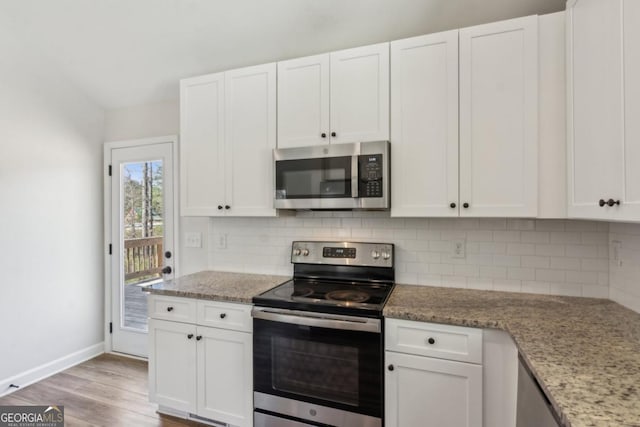 3143 Lee Cir, Buford, GA 30518 - kitchen with white cabinetry, stainless steel appliances, light wood finished floors, and decorative backsplash