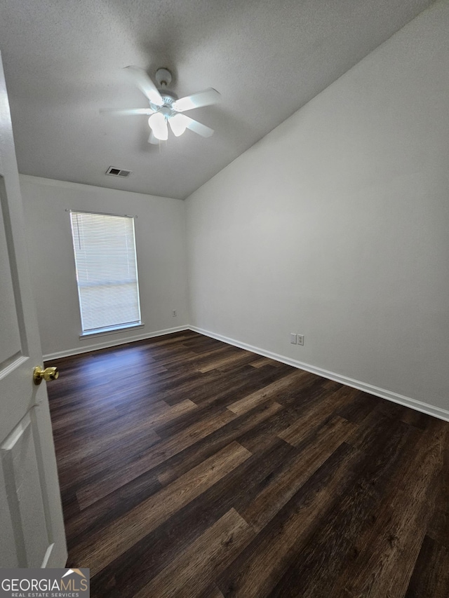 unfurnished room with dark wood-style flooring, baseboards, ceiling fan, and visible vents