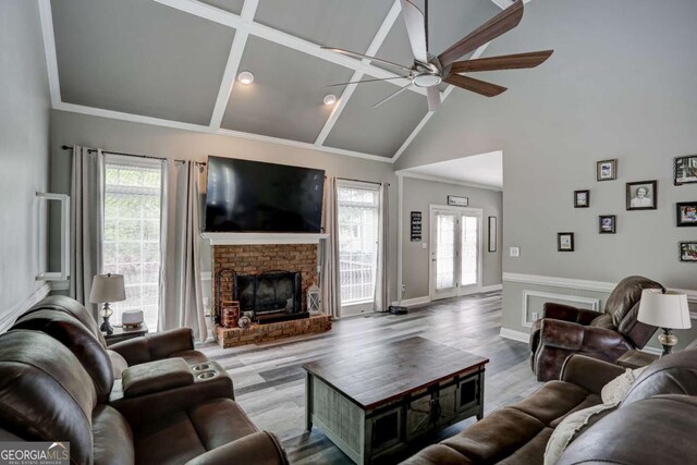 living room featuring a brick fireplace, a wealth of natural light, wood finished floors, and ceiling fan
