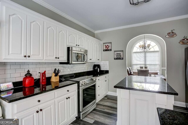kitchen with white cabinets, dark wood-style flooring, ornamental molding, and appliances with stainless steel finishes