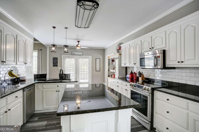 kitchen featuring white cabinetry, a sink, crown molding, and appliances with stainless steel finishes