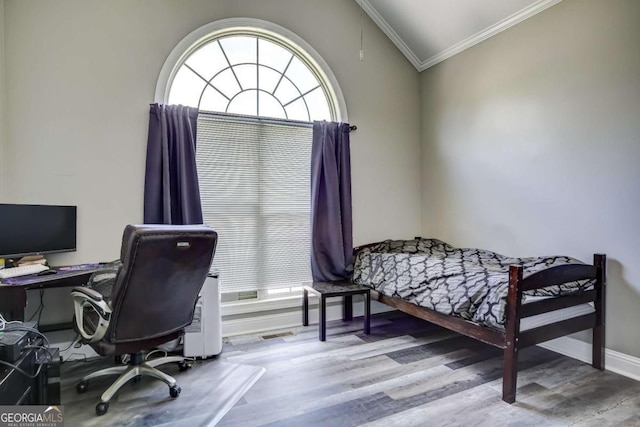 bedroom with crown molding, baseboards, and wood finished floors