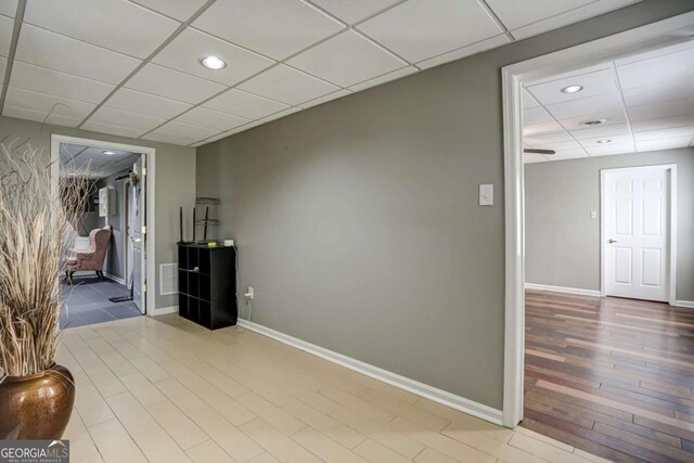 interior space featuring baseboards, wood finished floors, recessed lighting, and a drop ceiling
